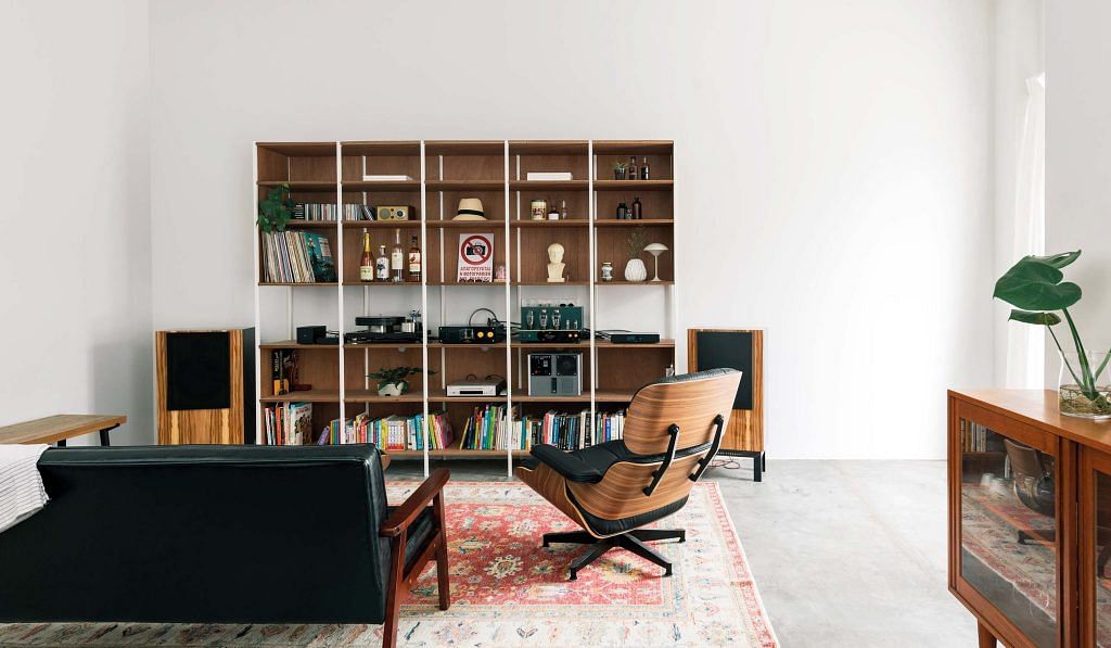 The couple enjoys relaxing to music and a vintage hi-fi makes for a fitting showpiece in their living room alongside a custom-built plywood shelving unit.