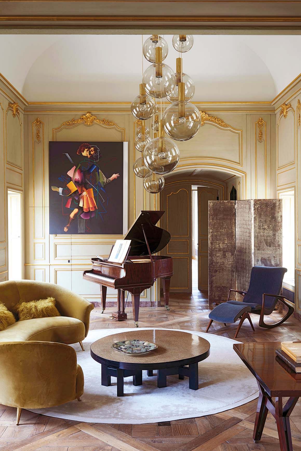 The living area features a 19th century Grand Erard piano and Versailles parquet; a bespoke screen in lacquered white gold created by Atelier Maury, and a Grain de poivre coffee table by Ado Chale. The painting “Shadow of Past” is by Pieter Schoolwerth (from Galerie Nathalie Obadia).