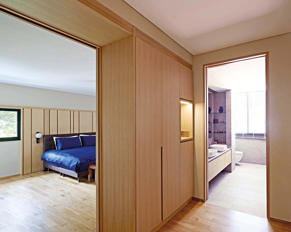 A timber pocket door separates the walk-in wardrobe from the sleeping area within the master bedroom.