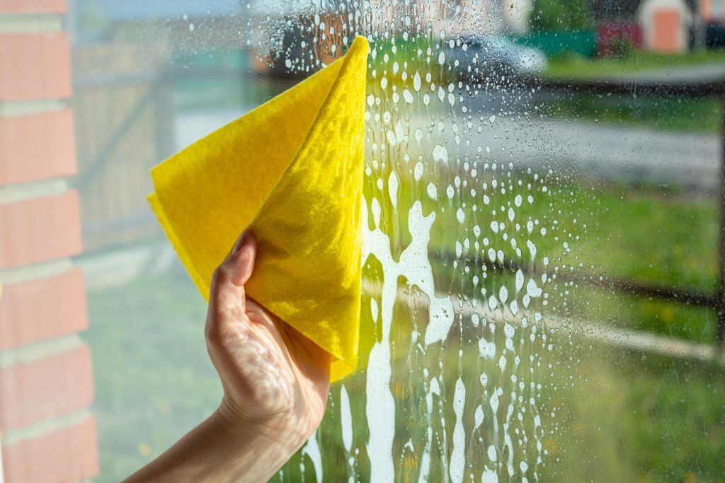 Female hand with yellow cloth cleaning the window. House cleaning concept. Image from 123RF
