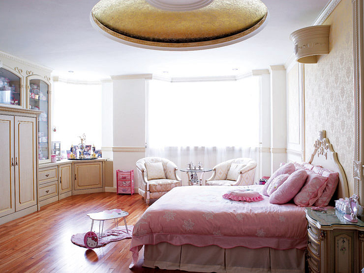 The ceiling of the attic-level master bedroom was specially sponge-painted to create a dreamy effect, like that of clouds floating in the sky. The master bedroom exudes a dignified air with grand gestures like the round ceiling alcove above and bespoke furniture.