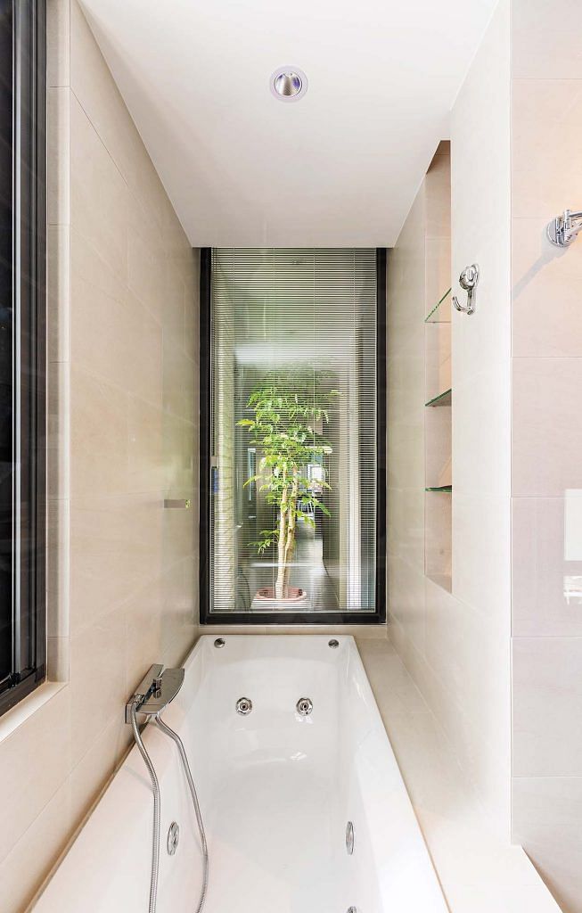 A large semi-translucent glass window lets natural light into the bathroom.