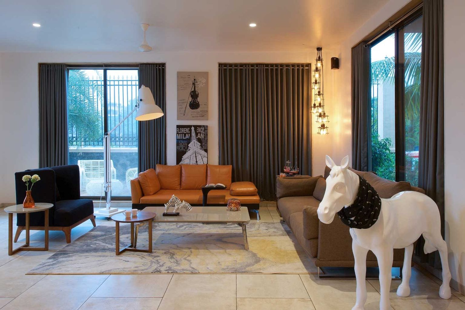 Designed by Mumbai-based architects Gaurav Kharkar & Associates, this family home has a timeless, elegant and artsy look. The living room exudes a warm ambience, and is decorated with sculptures and statement lighting.