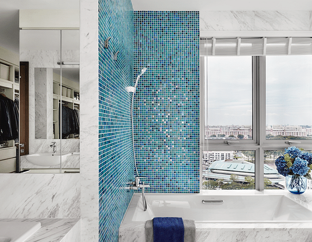 The marble grain contrasts with the shimmering mosaic tiles for a clean look in this bathroom.
