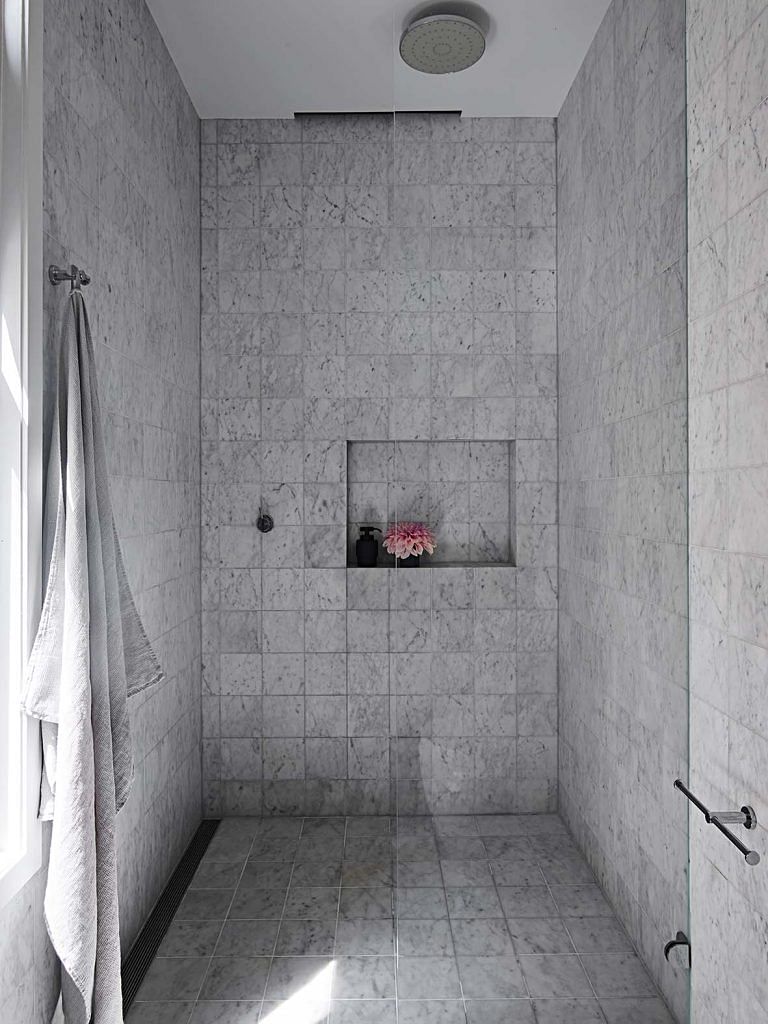 The plainly styled bathroom is enhanced with the textured stone tile cladding.