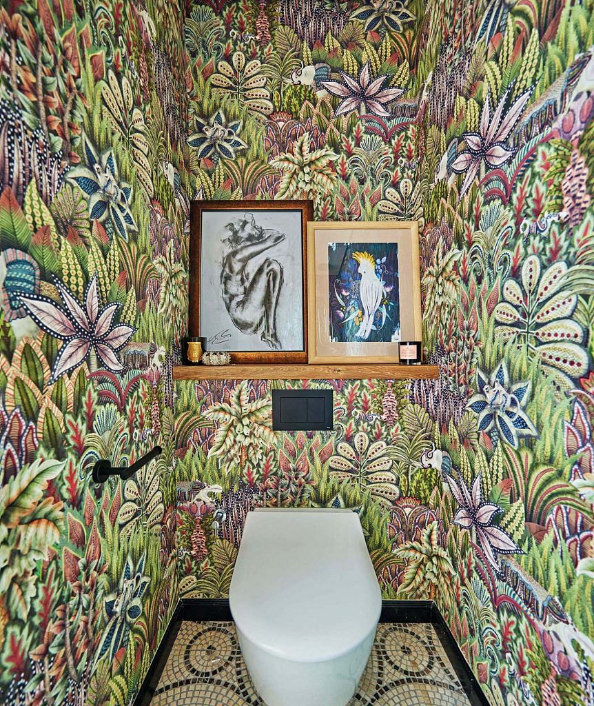 The powder room adds an element of surprise to the home with its Cole & Son wallpaper in a riot of colours.