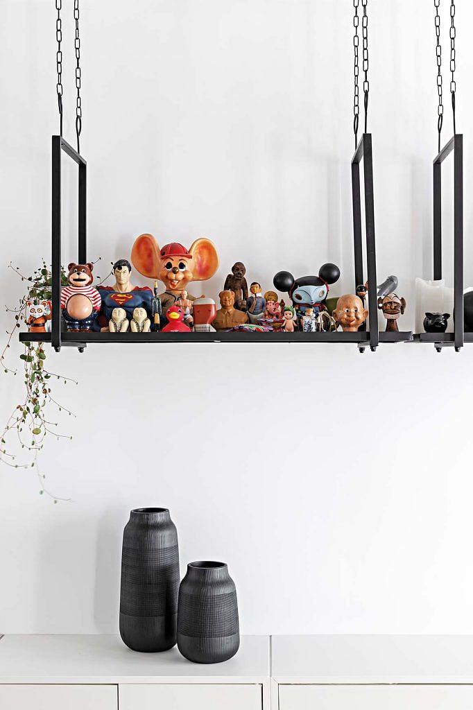 A hanging shelf showcases the homeowner’s collection of figurines.
