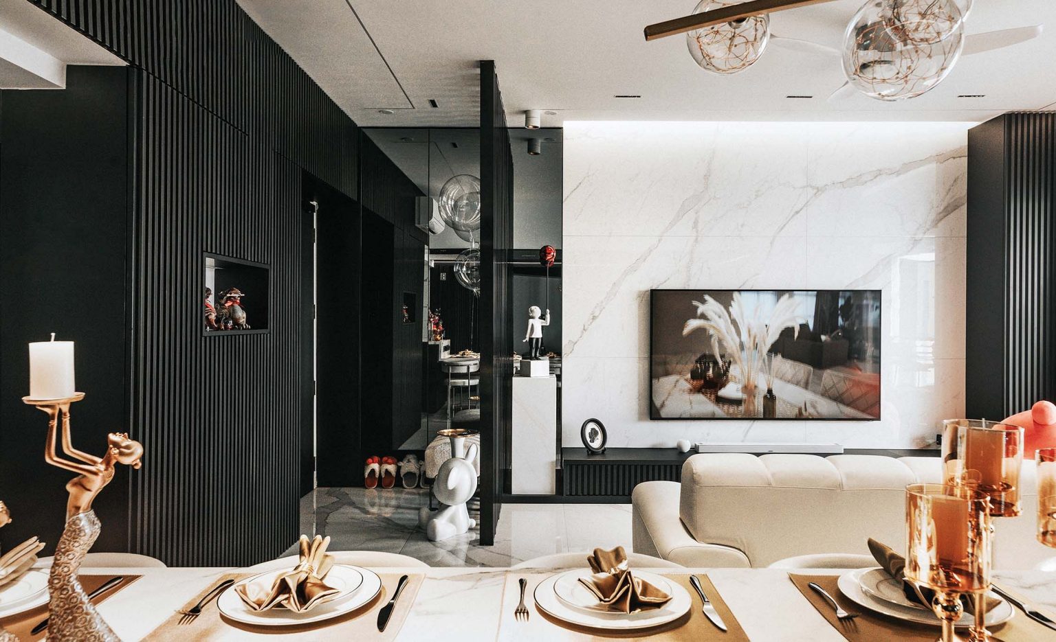 Marble TV wall and black and gold accents contribute to a modern luxury look
