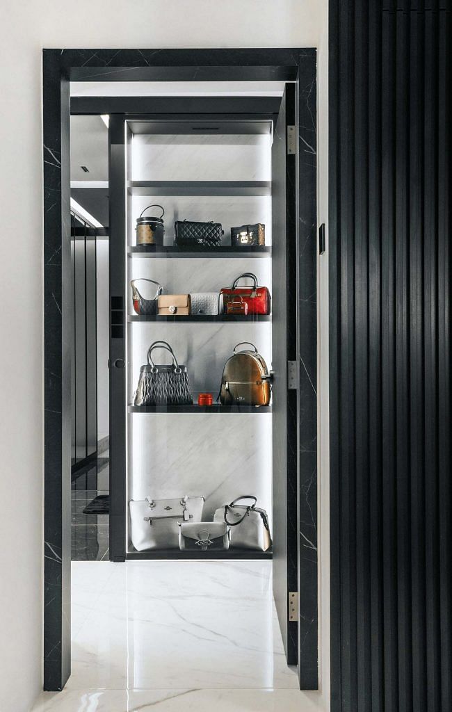 View into a doorframe reveals a full length closet with luxury bags