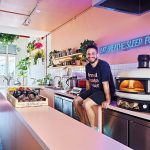 Chef Alberto Simillides designed the kitchen of Proud Potato Peeler in the style of Mediterranean homes. Next to him is a high heat pizza oven imported from Britain.