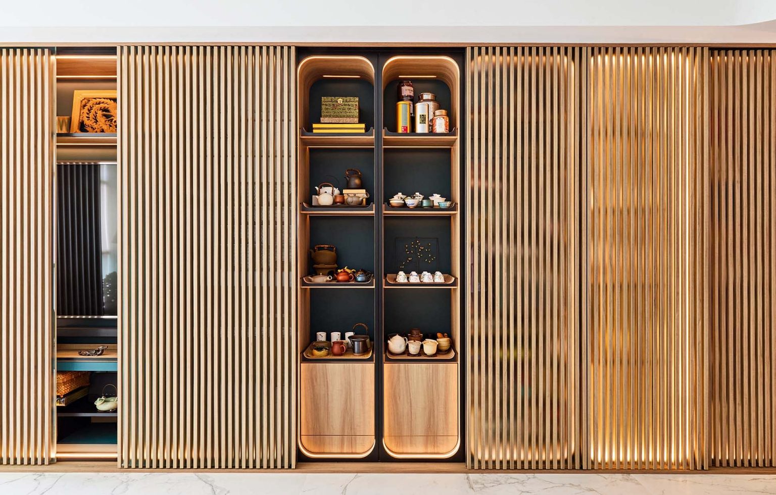 Subtly lit sliding screens help to conceal extra shelving to create a streamlined look.