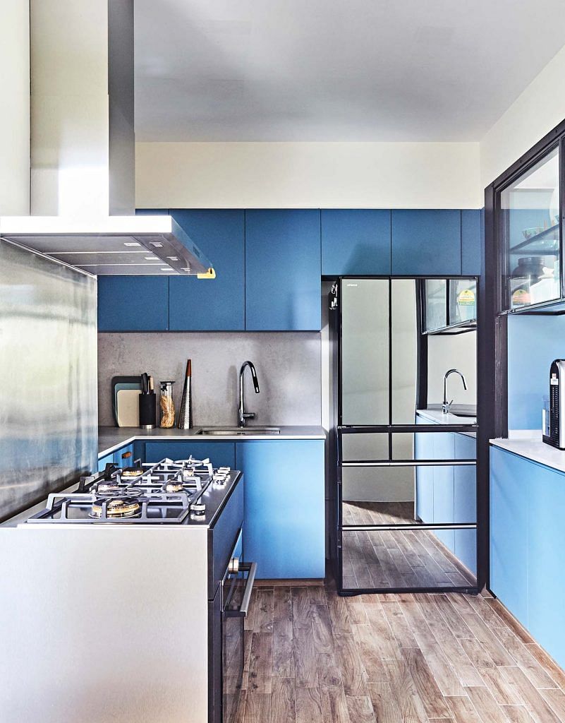 The wet kitchen can be completely sealed off without losing visual connection to the main living area thanks to a sash window and glass door. The fridge’s mirror finish enlarges the space.