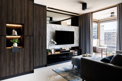 The TV feature wall comprises marble finish that add a touch of luxe, and a strip of mirrored panel above it that makes the space feel more spacious.