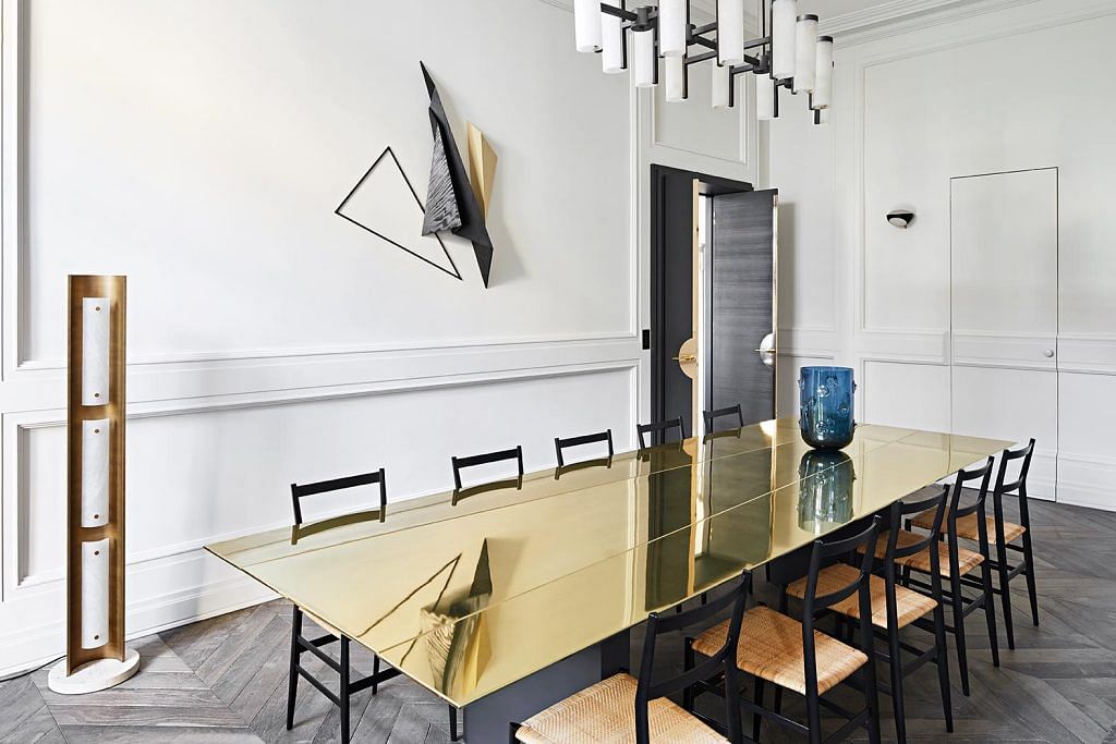 The dining table has a simple rectangular form and structure, but makes a statement with its reflective brass finish.