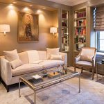 The Baker camelback sofa fits perfectly in the recessed space within the library, reupholstered in a silk/cotton velvet from Kravet. The well- appointed room also features swing-arm sconces from Vaughan and an iron-and-glass coffee table from Lillian August.