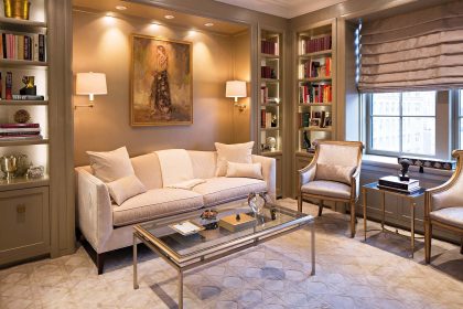 The Baker camelback sofa fits perfectly in the recessed space within the library, reupholstered in a silk/cotton velvet from Kravet. The well- appointed room also features swing-arm sconces from Vaughan and an iron-and-glass coffee table from Lillian August.