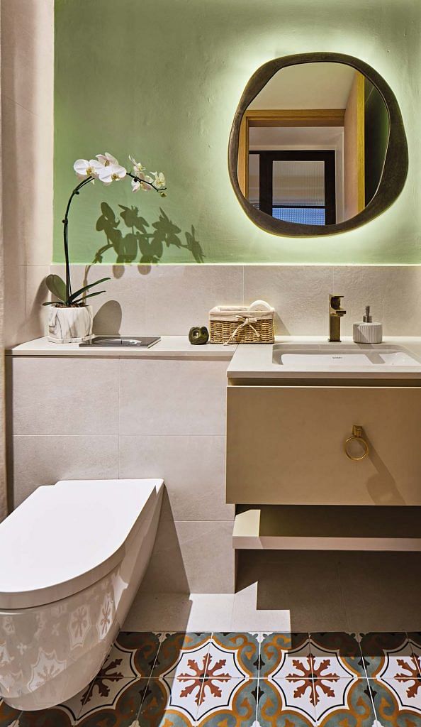 Patterned tiles and a pastel green wall lend freshness to this bathroom.