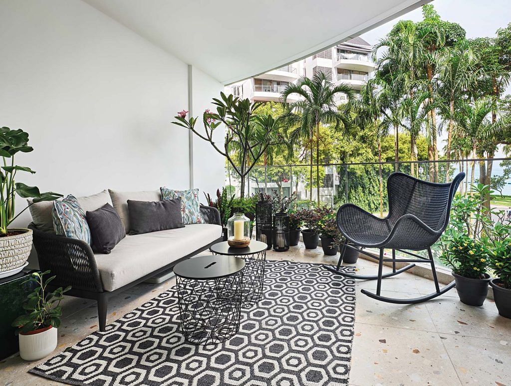 The balcony features black and white furnishing softened by plenty of greenery.