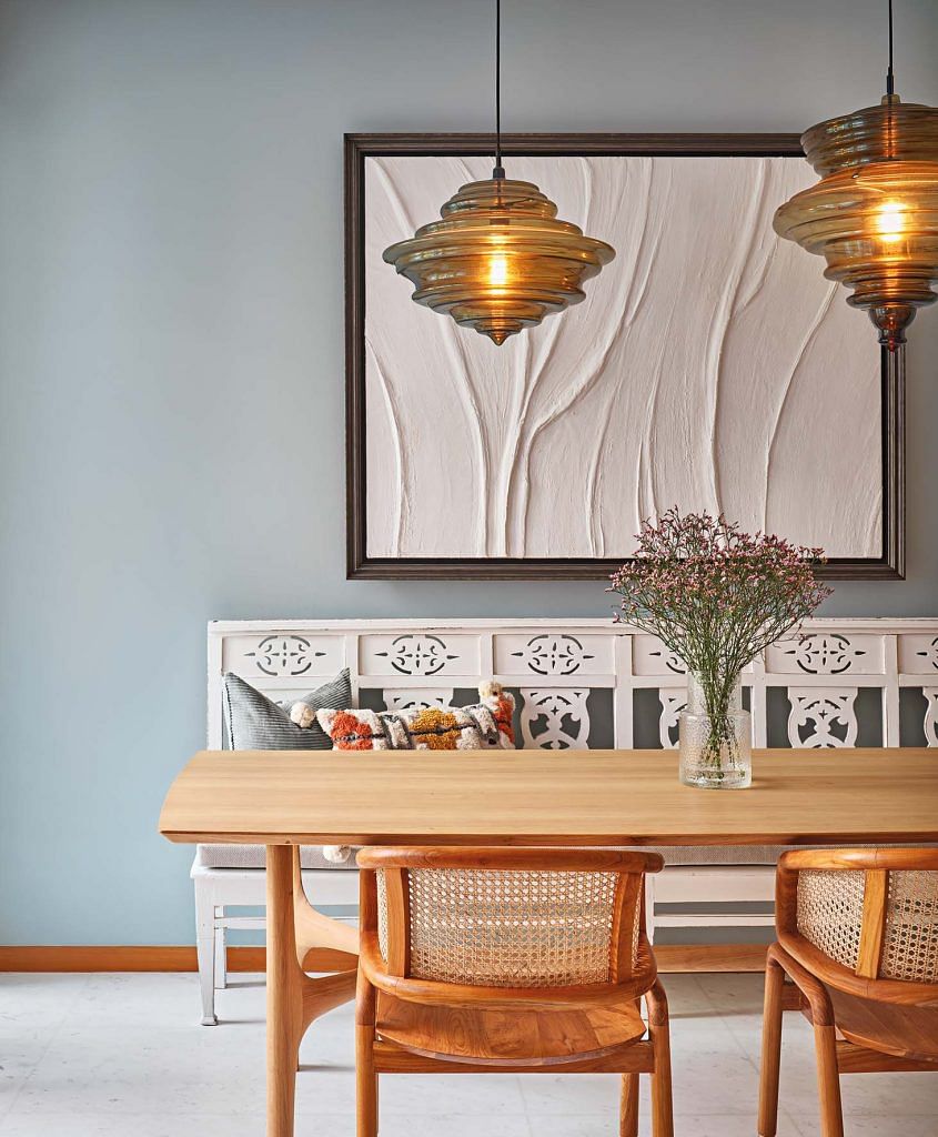 The dining room balances cool and warm tones beautifully. The ornate bench was reclaimed from a post office in India.