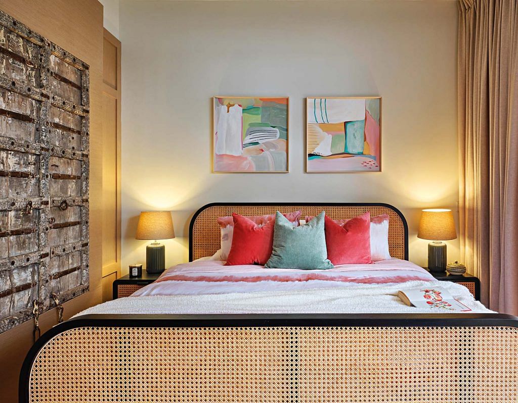 The woven cane bed frame and pastel artworks and cushions in the bedroom are a perfect blend of the couple’s personalities.