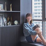 Stephanie Chua, a female master financial consultant strikes a pose on the bay window of her 2-room condo in Telok Blangah
