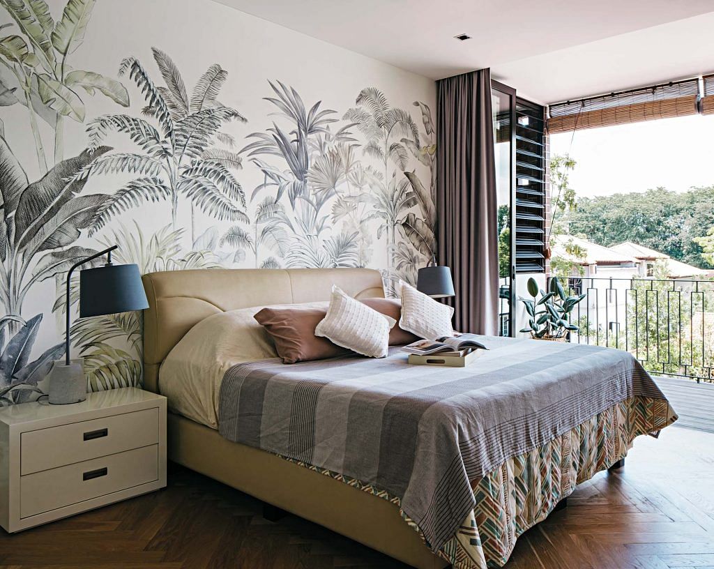 A double bed in front of a wall with tropical print