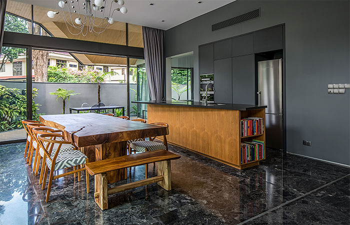 A large, solid wood table is positioned in the middle of the dining room in order to facilitate family meals in this semi-detached house in Trevose Place, Bukit Timah.