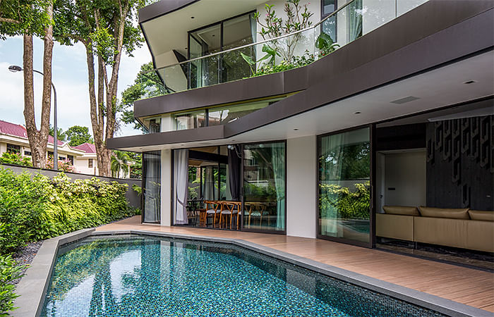 Wooden plank flooring extends from the patio to the side of this semi-detached house in Trevose Place, Bukit Timah, where the swimming pool is, creating a pool deck effect.