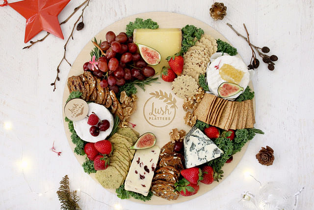 Grazing table and board ideas for Christmas. Christmas wreath-shaped cheese charcuterie grazing table. Image from Lush Platters