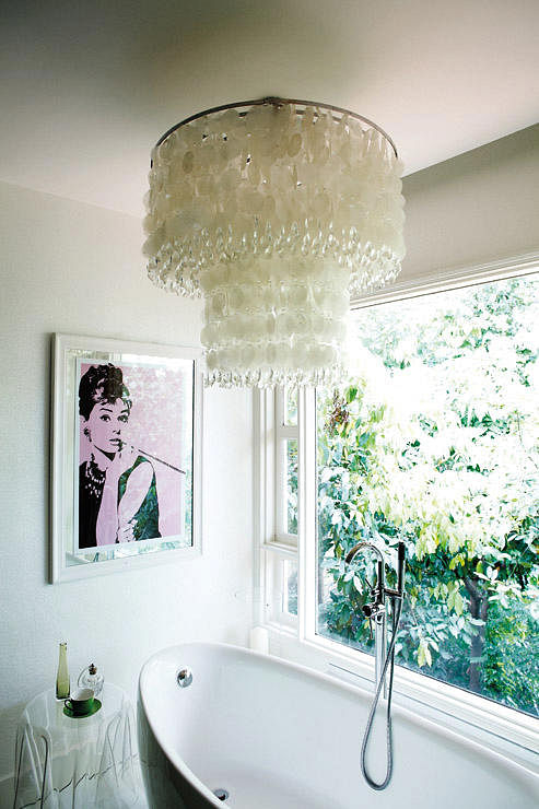 Chandelier placed in a bathroom, above a bathtub
