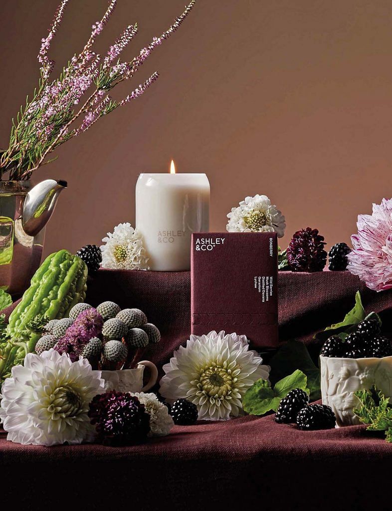 AShley and co candles surrounded by flowers and berries