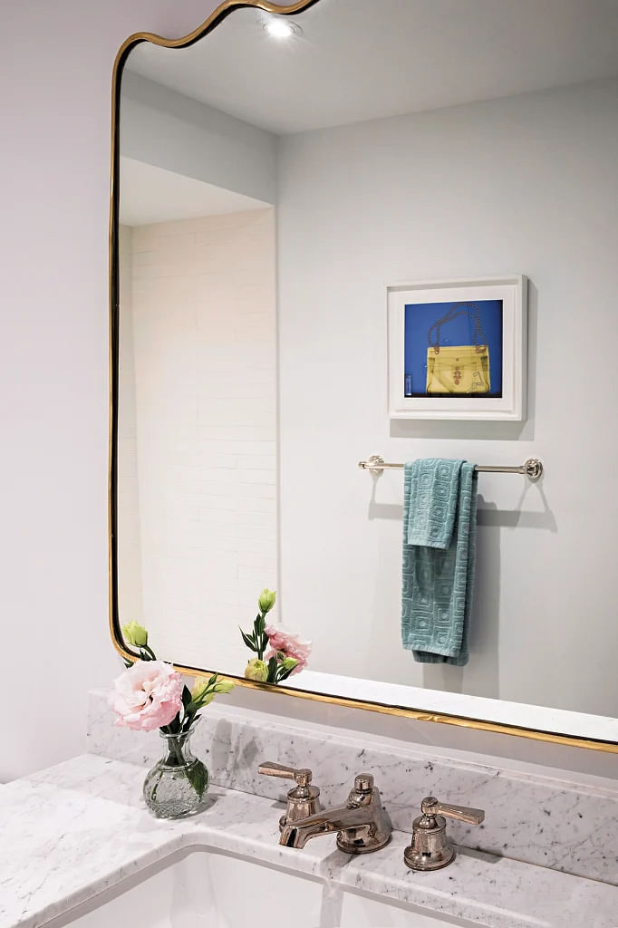 The curved edges of the mirror softens the look in the bathroom.
